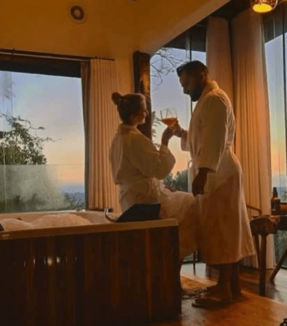 Casal apreciando o pôr do sol na suíte