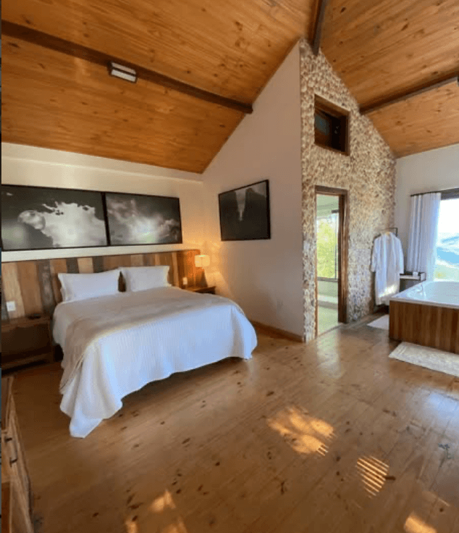 Suíte com obras de arte e teto em madeira